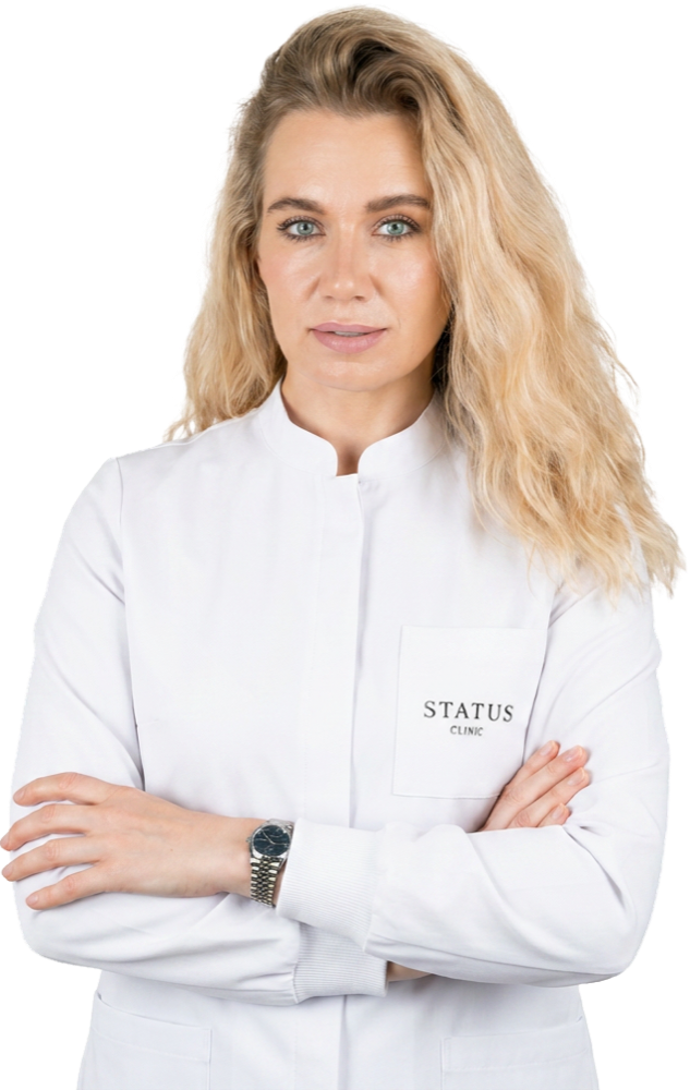 Dr. Olga Voronets, TMJ specialist at STATUS CLINIC, in a white STATUS CLINIC uniform